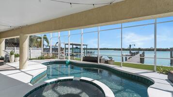 Una piscina interior con vista a un lago y un muelle.