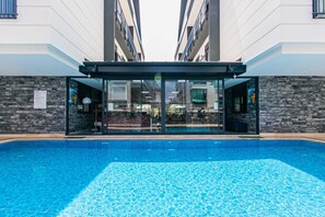 Um edifício moderno com piscina em frente.