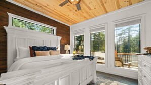 A bedroom with a large bed, wooden ceiling, and large windows. - The Grinning Bear|Sleeps 14|Basketball|Pickleball (Broken Bow)