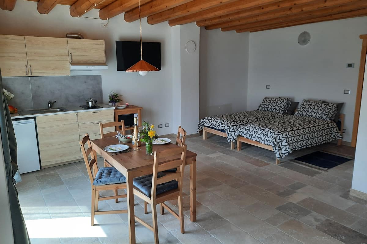 A compact living space with a kitchen, dining area, and a bed.