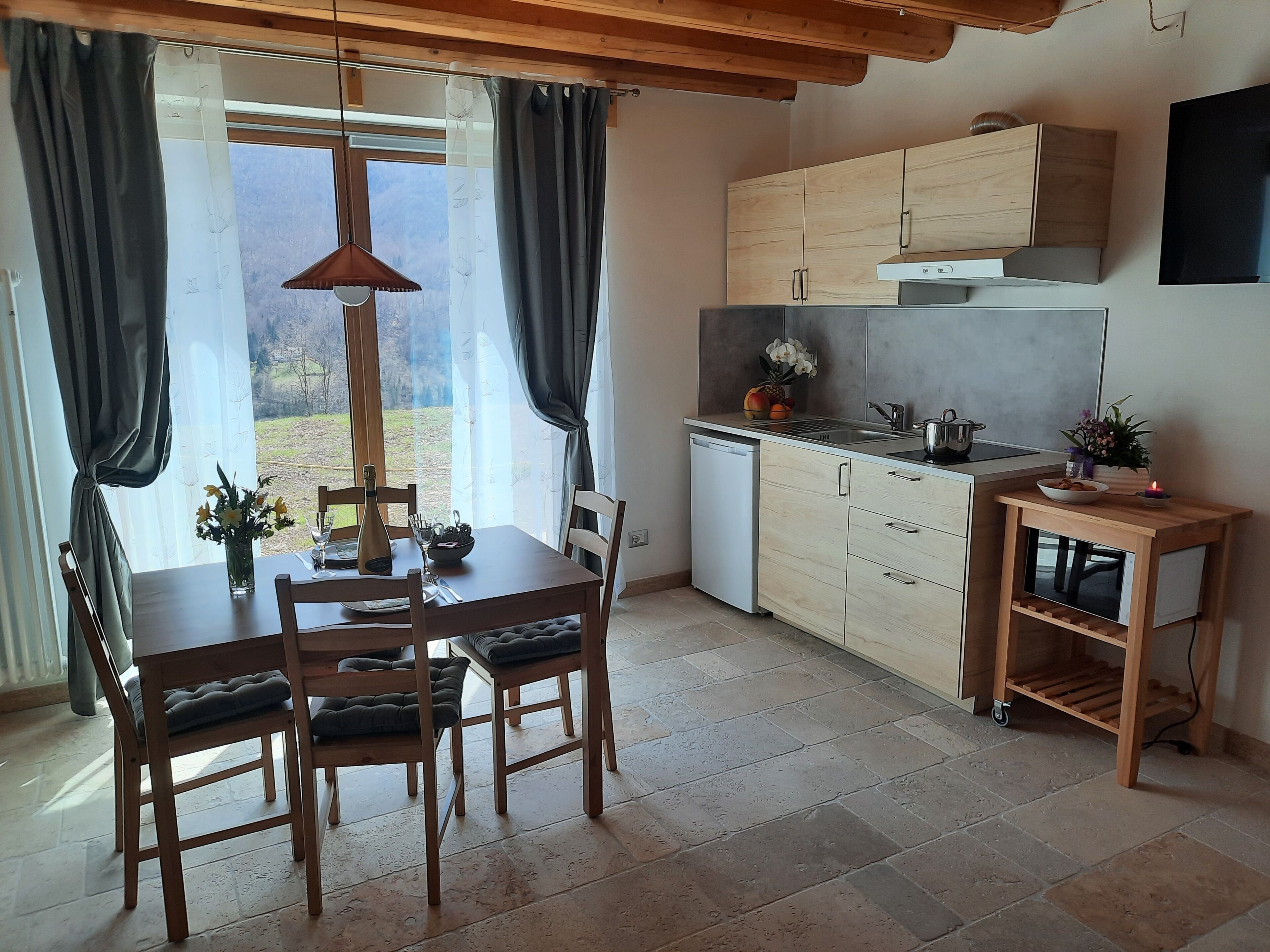 Eine moderne Küche mit Holzausstattung, einem eingebauten Backofen und einer kleinen Kochinsel mit Spüle.