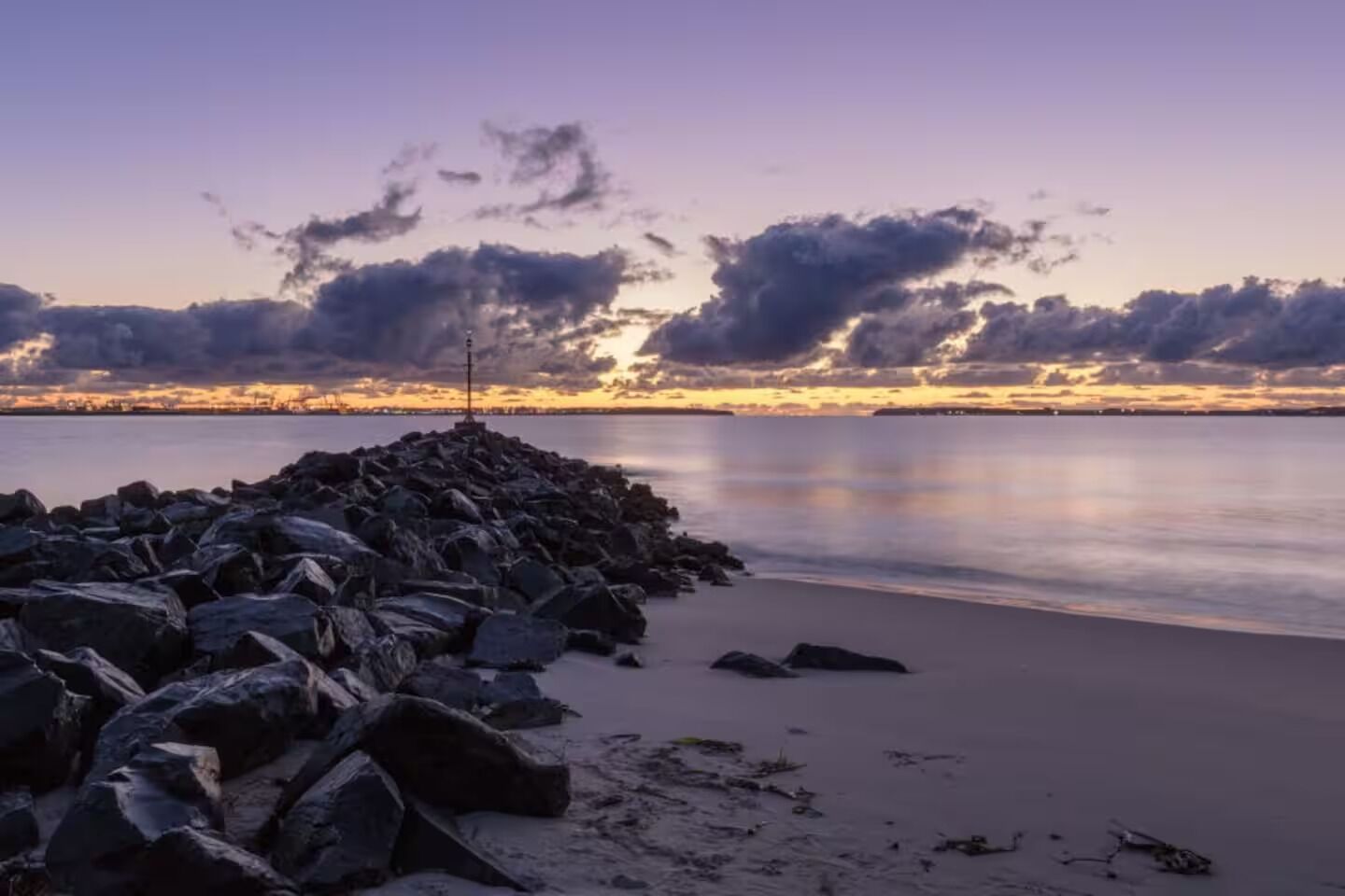 Une côte rocheuse, avec un phare à son extrémité.