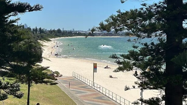 A beach with a paved walkway, trees, and a clear view of the ocean. - 5 minutes to the beach!  (Brighton-Le-Sands)