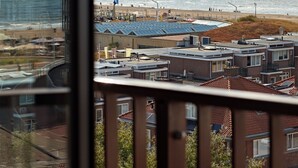 A coastal view with a beach, sea, and buildings in the foreground. - Numa The Hague Scheveningen (The Hague)