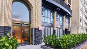 Un bâtiment moderne avec une entrée en verre portant l’inscription « Numa ».