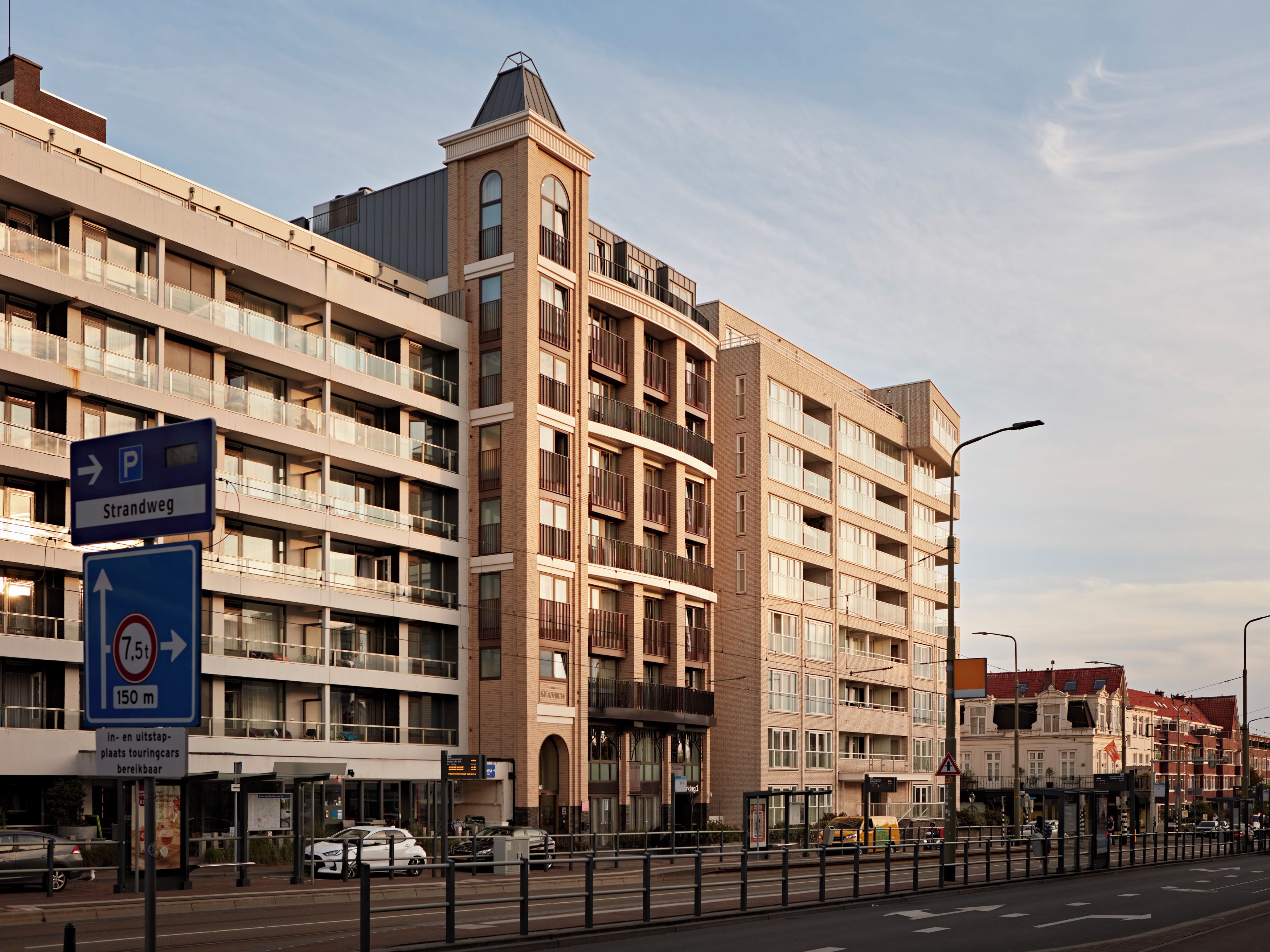 A multi-story building with a parking sign indicating a 7.5-minute walk to the Strandweg.