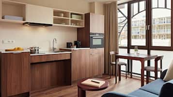 Una cucina moderna con mobili in legno, forno integrato e zona pranzo con tavolo e sedie.