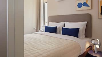 A hotel room with a bed, bedside tables, and a window with curtains.
