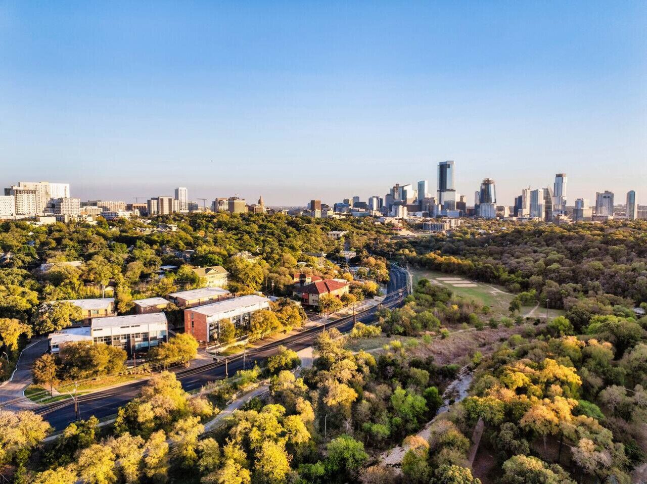 Une vue aérienne d’une ville où se côtoient des immeubles de grande hauteur et un parc arboré.