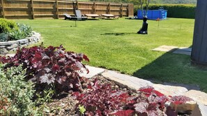 Un jardin bien entretenu, avec une clôture en bois, une piscine et une pelouse.