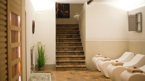 A spa area with a staircase leading to a bathroom, a reception desk, and a row of massage chairs. - Borgo Le Noci Chianti Retreat & Pool (Gaiole in Chianti)