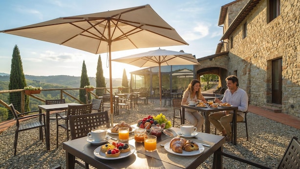 A terrace with outdoor seating, tables, and umbrellas, overlooking a scenic landscape. - Borgo Le Noci Chianti Retreat & Pool (Gaiole in Chianti)