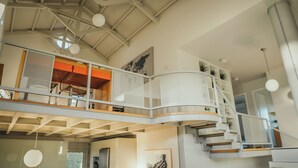 A spacious interior with a high ceiling, a mezzanine level with a railing, and a staircase leading to an upper floor. - Thea II Sea View Private Pool Villa, Nikiti (Nikiti)