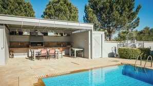 An outdoor pool area with a covered barbecue and seating. - Thea II Sea View Private Pool Villa, Nikiti (Nikiti)