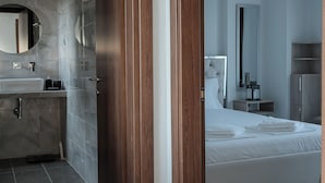 A modern hotel room with a bathroom, a bed, and a wardrobe. - Callisto Private Pool Villa, Pefkochori (Pefkochori)