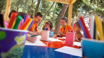 A group of people sitting at a table with colorful stationery items.