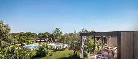 Eine moderne Außenpatio mit Pool, umgeben von üppiger Vegetation und Bäumen.