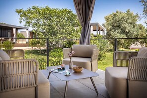 A balcony with wicker furniture, a table with a vase and a bowl, and a view of greenery and buildings. - Aminess Planet Camping Holiday Homes Sirena (Novigrad)