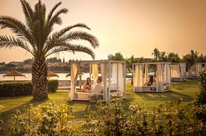 A resort with outdoor seating areas, palm trees, and a view of the water. - Aminess Planet Camping Holiday Homes Sirena (Novigrad)