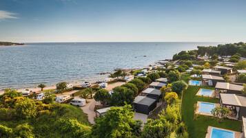 A coastal RV park with swimming pools and a beach.