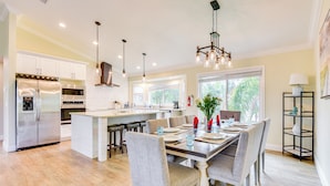 A modern kitchen with white cabinets, stainless steel appliances, and a central island. - Walk to Ocean: Home w/ Pool in Holmes Beach (Holmes Beach)