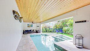 A swimming pool with a wooden ceiling and a view of a garden. - Walk to Ocean: Home w/ Pool in Holmes Beach (Holmes Beach)