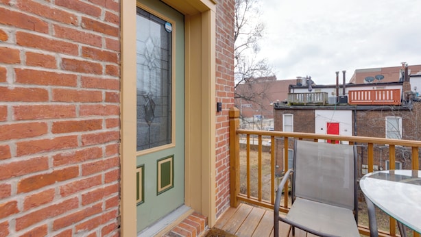 A brick building with a green door and a wooden deck. - Walkable Area: Spacious Apt in Dtwn St Louis (St. Louis)