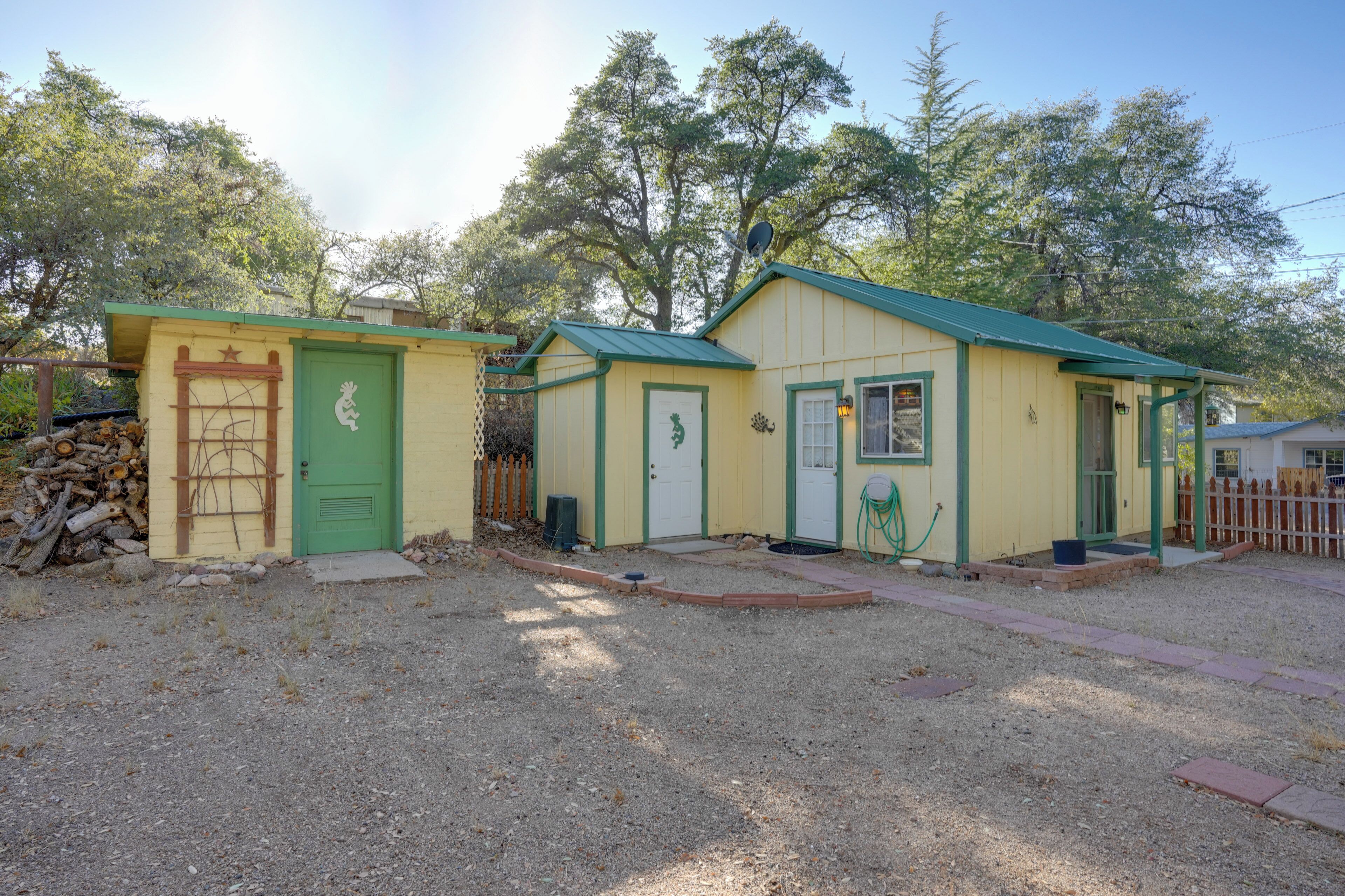 A small, single-story building with a green door and a small porch.