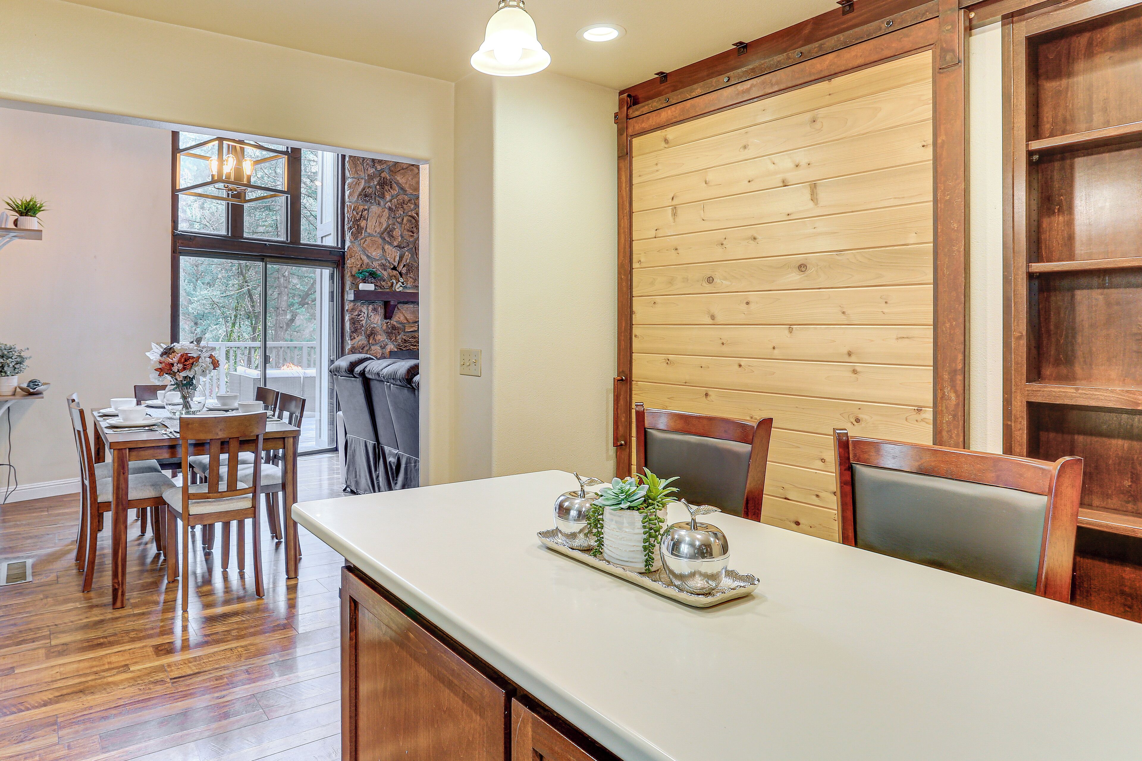 Un comedor con mesa de madera, sillas y una bandeja decorativa con plantas.