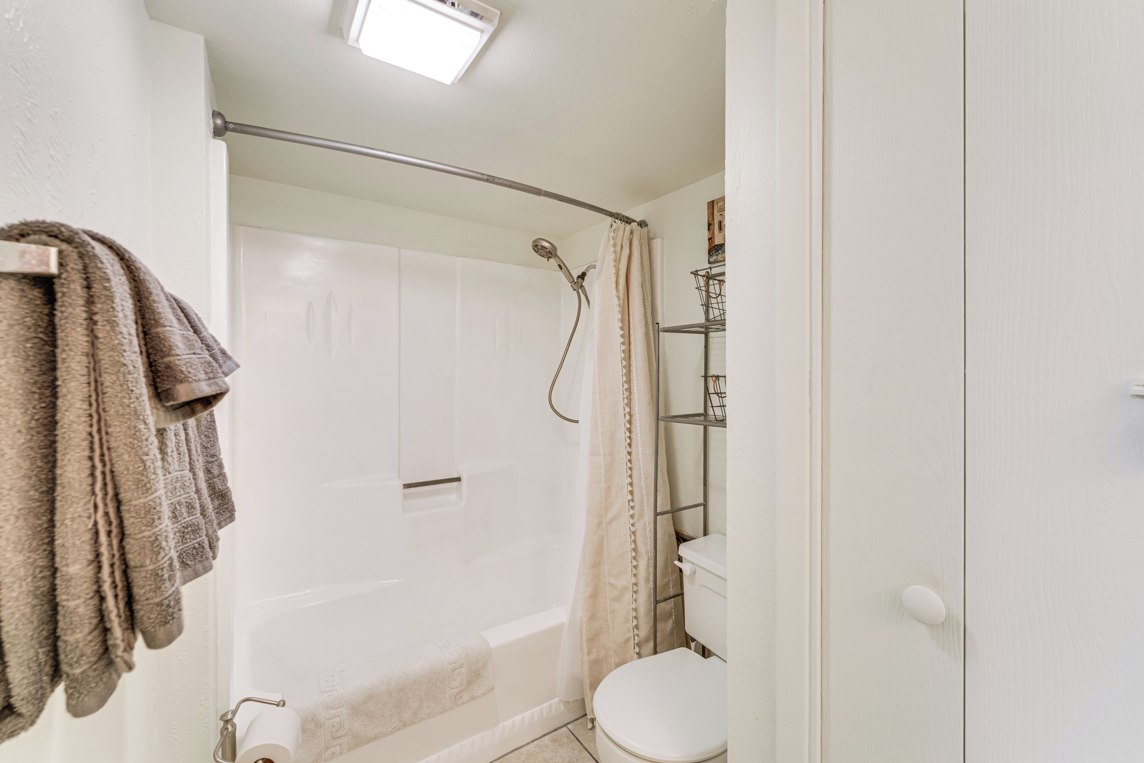 Une salle de bain avec une baignoire, des toilettes et un rideau de douche.