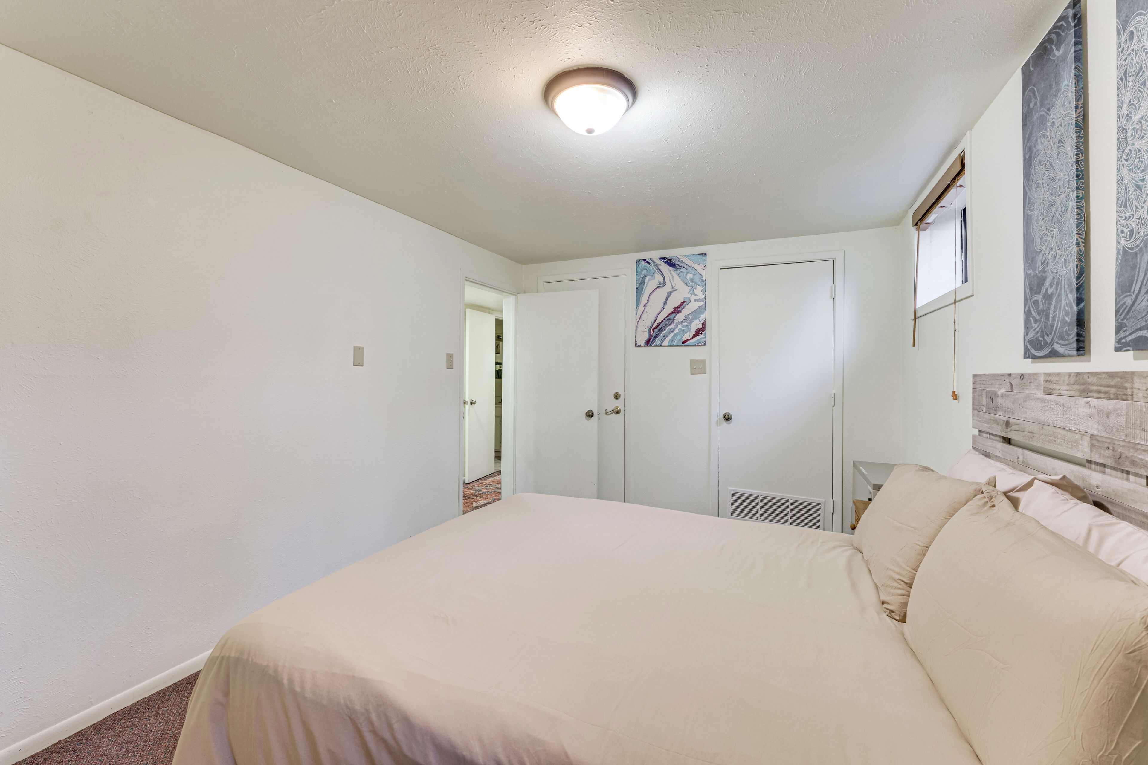 A bedroom with a large bed, a wardrobe, and a ceiling light.