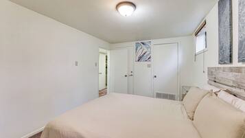 A bedroom with a large bed, a wardrobe, and a ceiling light.