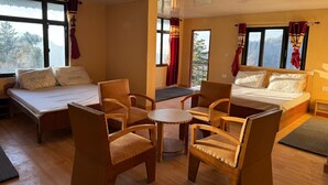 Een hotelkamer met twee bedden, een tafeltje en vier stoelen.