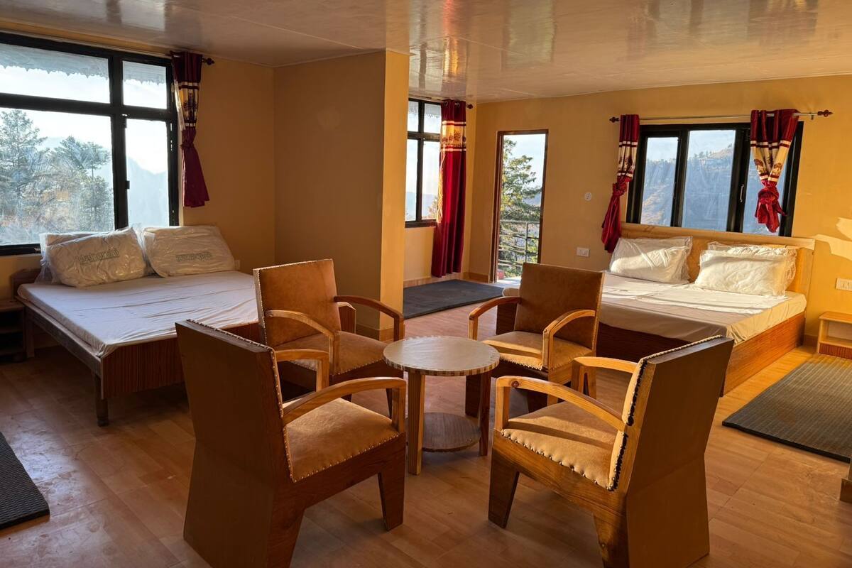 A hotel room with two beds, a small table, and four chairs.