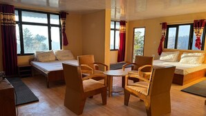 Een gezellige kamer met een bed, twee stoelen, een kleine tafel en een bureau.