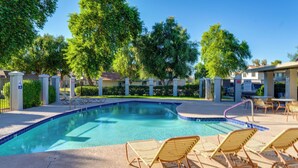 A swimming pool with lounge chairs, surrounded by trees and a gated entrance. - Community Pool: Scottsdale Condo 2 Mi to ASU (Scottsdale)
