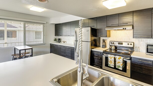 A modern kitchen with stainless steel appliances, a large island, and a dining area with a table and chairs. - Community Pool: Scottsdale Condo 2 Mi to ASU (Scottsdale)