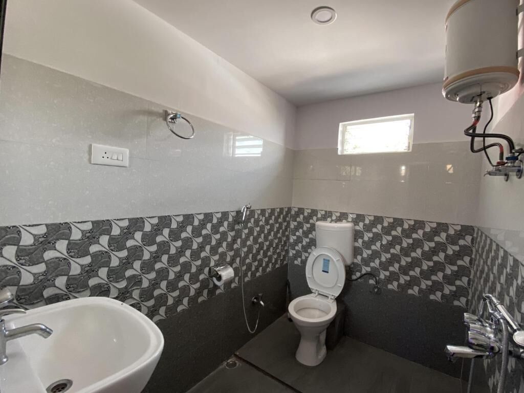 A bathroom with a toilet, sink, and shower.
