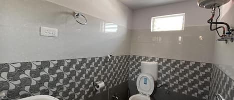 Baño con inodoro, lavabo y ducha.