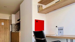 A modern office space with a black office chair, a red sign, a bottle of hand sanitizer, and a 'BYE FOR NOW!' sign. - w Radiant 1BR in Santa Barbara (Bogotá)