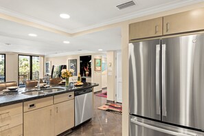 A modern kitchen with stainless steel appliances, a dishwasher, and a large refrigerator.