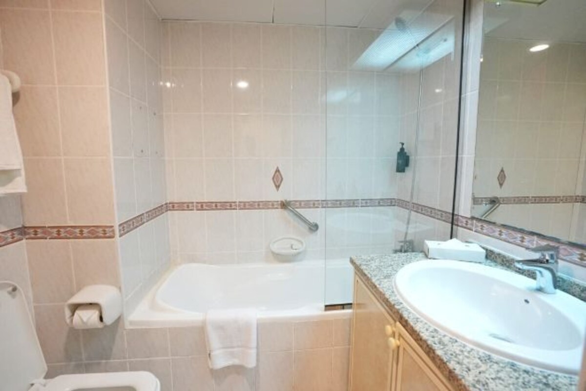 Ein Badezimmer mit Badewanne, Waschbecken, Toilette und Spiegel.