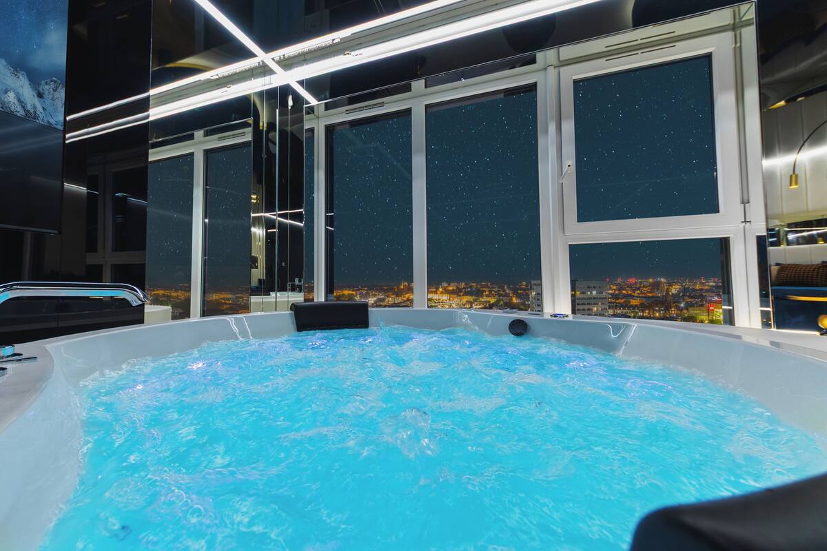Ein Whirlpool mit Blick auf die Stadt durch große Fenster.