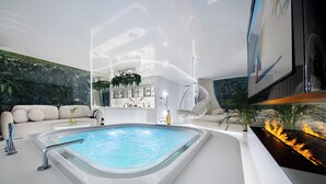 A modern interior with a hot tub, seating area, and a fireplace. - Quorum Apartments (Wroclaw)