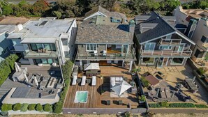 Une grande maison dotée d’une vaste terrasse, d’un espace salon extérieur et d’une piscine.
