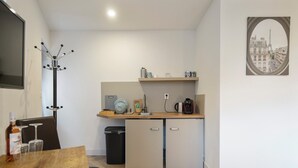 Eine kleine Küche mit Holzarbeitsplatte, einer Kaffeemaschine und einem kleinen Kühlschrank.