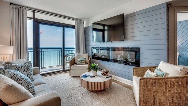 A modern living room with a sofa, armchairs, a coffee table, and a fireplace. - 🌴Large Oceanfront~Lazy River~Awesome Amenities~ Caribbean Resort 1105🌴 (Myrtle Beach)