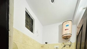 A small bathroom with a toilet, sink, and shower. - Luxe Heaven (Jaipur)