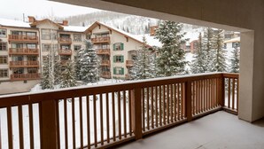 A balcony with a wooden railing overlooking a snow-covered landscape with buildings and trees. - 3323 - Two Bedroom Standard Powderhorn Lodge 2 Condo (Salt Lake City)