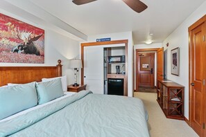 A hotel room with a bed, a desk, a microwave, and a physical therapy sign. - 1311b - King Standard Eagle Springs West Hotel Room (Solitude)